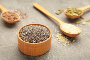 Healthy superfood: sesame, pumpkin seeds, sunflower seeds, flax seeds and chia on grey. Seeds on spoon