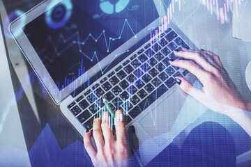 Double exposure of woman hands working on computer and forex chart hologram drawing. Top View. Financial analysis concept.