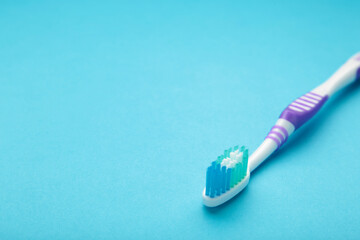 Lilac toothbrush on a blue background with copy space.