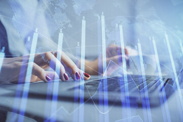 Multi exposure of woman hands typing on computer and financial graph hologram drawing. Stock market...