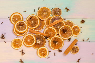 Set for mulled wine on a rainbow background, scattered dry oranges, cinnamon, cloves, star anise,...