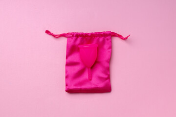 Menstrual cup on pink background top view