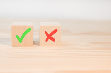 Tick mark and cross mark x on wooden cubes. Wooden blocks with green check mark and red x. Choice...