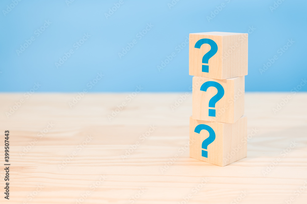 Poster cubes with blue question marks on wooden background, closeup. space for text. wooden cubes with ques