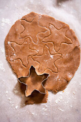 Raw rolled gingerbread dough, cutting festive shaped cookies