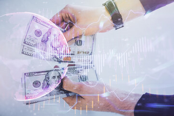 Multi exposure of financial graph drawing hologram and USA dollars bills and man hands. Analysis concept.