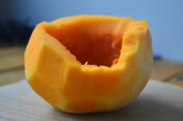 Sliced ​​orange pumpkin on a wooden board. Fresh vegetables without skin. Pieces.
