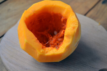 Sliced ​​orange pumpkin on a wooden board. Fresh vegetables without skin. Pieces.