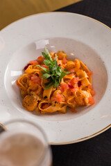 fettuccine pomodoro pasta with tomatoes on white plate on the table