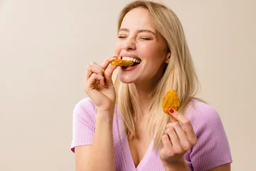 Rolgordijnen Cheerful beautiful girl laughing while eating nuggets on camera © Drobot Dean