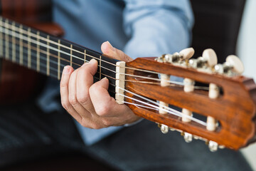 Male playing a note with the guitar