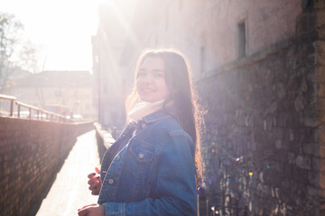 portrait of young dark haired woman exploring old beautiful city. Travel concept