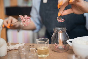 Young woman workplace in production of aromatic wax candles in shape of female Venus body in art studio. Concept craftswoman startup