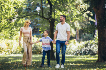 Young happy family with one children in the summer park