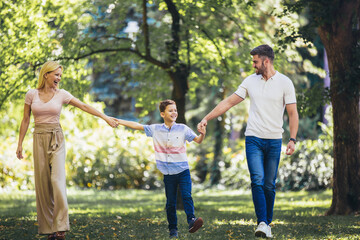 Young happy family with one children in the summer park