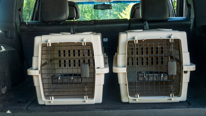 Two cages for the transport of pets in the trunk of a car