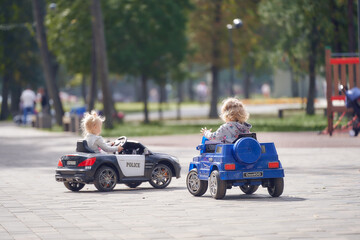 Small children drive, ride on children's toy cars. Back view. © Aleksandr