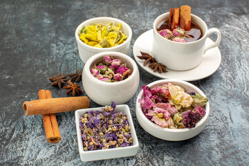 close up shot of herbal tea with dry flowers on grey background