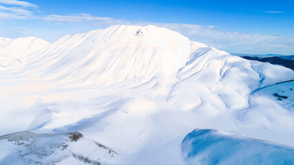 
Plain of Castelluccio di Norcia and Monte Vettore. Landscape covered with white snow seen from drone. uncontaminated landscape, the silence of nature