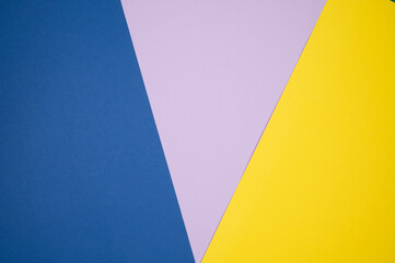 Multicolored abstract paper of pastel colors, with geometric shape. Blue, violet and yellow background.