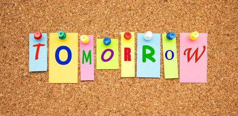 Color notes with letters pinned on a cork board. Word TOMORROW.