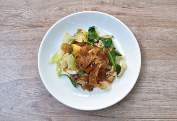 stir fried rice noodles with egg and Chinese kale in black sweet soy sauce on plate