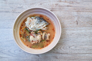 spicy boiled bass fish and head in tom yum soup on bowl