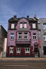 Typical houses in Cologne in Germany, particular and bright colors with pointed roofs. Some houses have murals and graffiti on the facade of the wall.