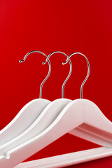 White hangers on a red background. Sales clothes concept.
