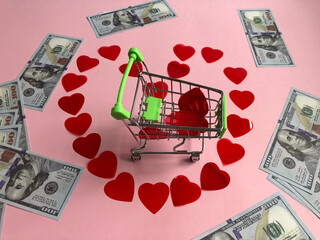  shopping cart in the centre of the heart made of small red hearts and banknote one hundred dollars 