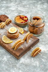Fototapeta premium Buttermilk pancakes with lemons on cutting board and cookies sweeties on blue background