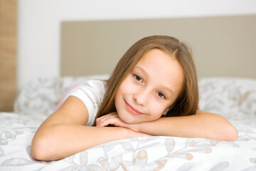 Obraz na płótnie Canvas Little girl in good mood in pajamas in the bedroom