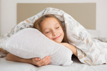 Little girl in good mood in pajamas in the bedroom