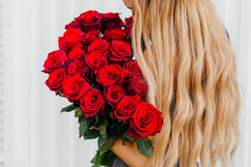 bouquet of red roses in the hands of blonde. High quality photo