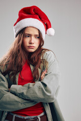offended girl in a cap crossed her arms on a gray background 