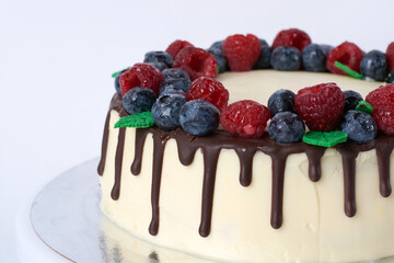 creamy cream cake with fresh berries and chocolate