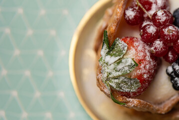 Dessert with custard cream and berries on golden plate. View from above,selective focus