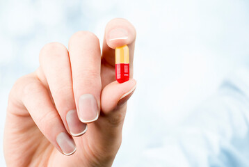 woman holding a capsule in her hand