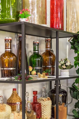 Glass large empty bottles and flasks, for wine and alcoholic beverages on a shelf in a shop window are sold on a shelf