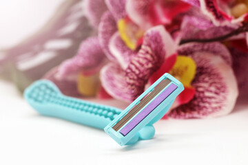 blue disposable razor and orchid flower