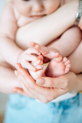 Obraz na płótnie Canvas little bab tiny legs and mother hands newborn