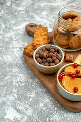 Delicious cakes with fruits honey and biscuits in a glass jar on a cutting board on blue background