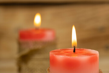 Two red candles on a wooden background, shallow depth of field.