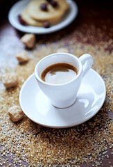 Cup of coffee and brown sugar on wooden background. Close up. 