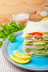  Sandwich with salmon, curd cheese and vegetables on the blue plate close-up