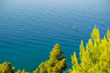Fototapeta na wymiar Image of man paddling board alone at the calm adriatic sea, Croatia.
