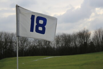 flag of whoöe 18 on a golf course
