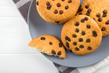 Delicious cookies with chocolate chips on a colored background