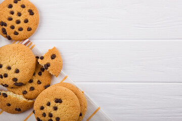 Delicious cookies with chocolate chips on a colored background