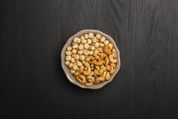 Hazelnut and cashew nuts on black background